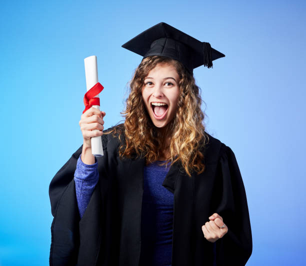 istock Excited young graduate waves her diploma joyfully. 1049220834