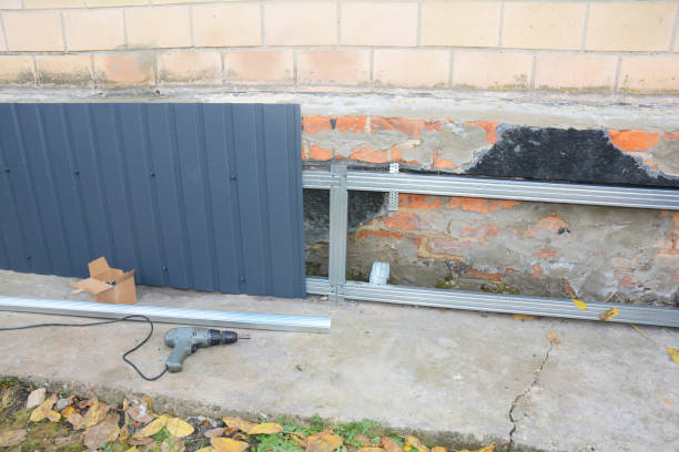 istock Old house foundation wall repair,  renovation  with installing metal sheets for waterproofing and protect from rain. 1049223308