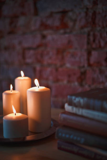 Still life in retro style with books on the table. Candlestick with an extinguished candle.