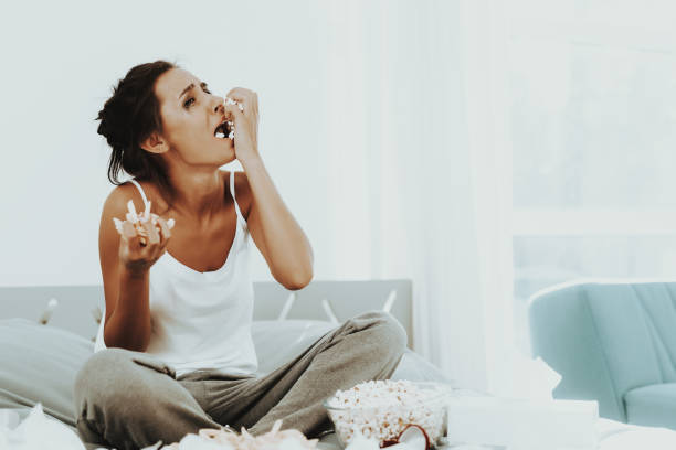 istock Lonely Crying Woman Is Eating Popcorn On The Bed. 1049230866