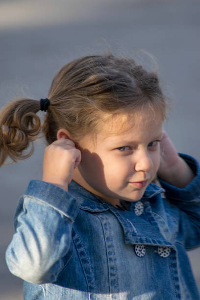 istock Little girl covering her ears 1049233538