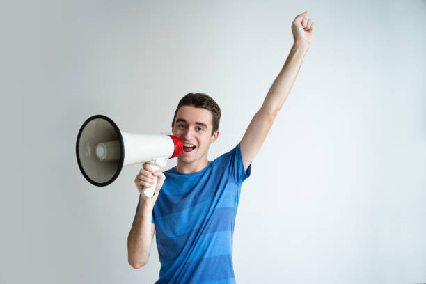 istock Happy man speaking into megaphone and raising arm 1049236940