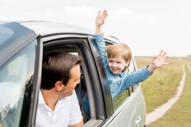 istock happy father and son riding car on nature together 1049237496