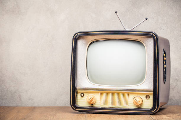 istock Retro old TV set receiver on table front textured concrete wall background. Broadcasting concept. Vintage style filtered photo 1049244646