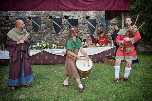 Monzambano, Mantova, Italy - September 16, 2018: Medieval reenactment in Italy, during a medieval festival re-enactment three musicians play their instruments, a flute, a bagpipe and a bass drum