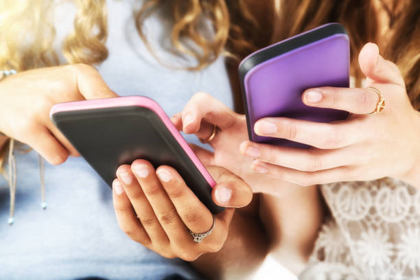 istock Two female hands tapping mobile phone screens 1049254890