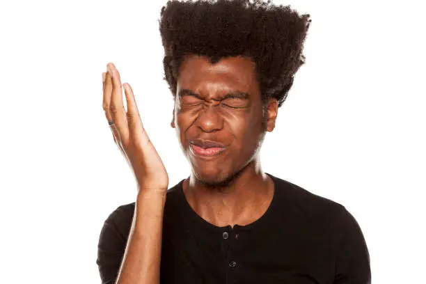 Photo of Portrait of young worried african american modern man slapped himself in the face on white background