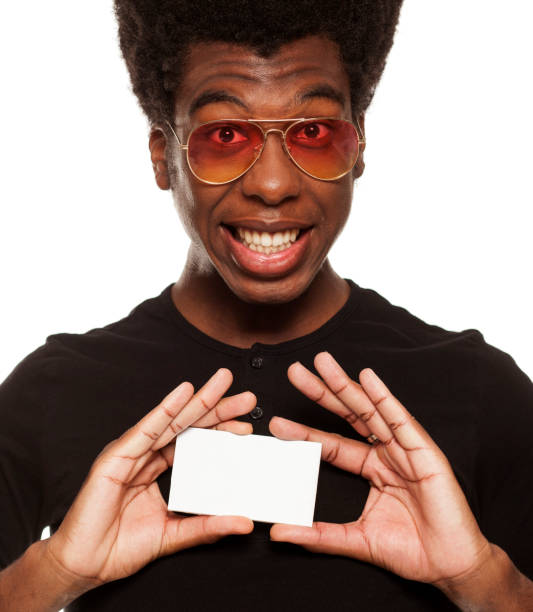 istock young handsome afro american guy holding credit card isolated on white background. 1049258556