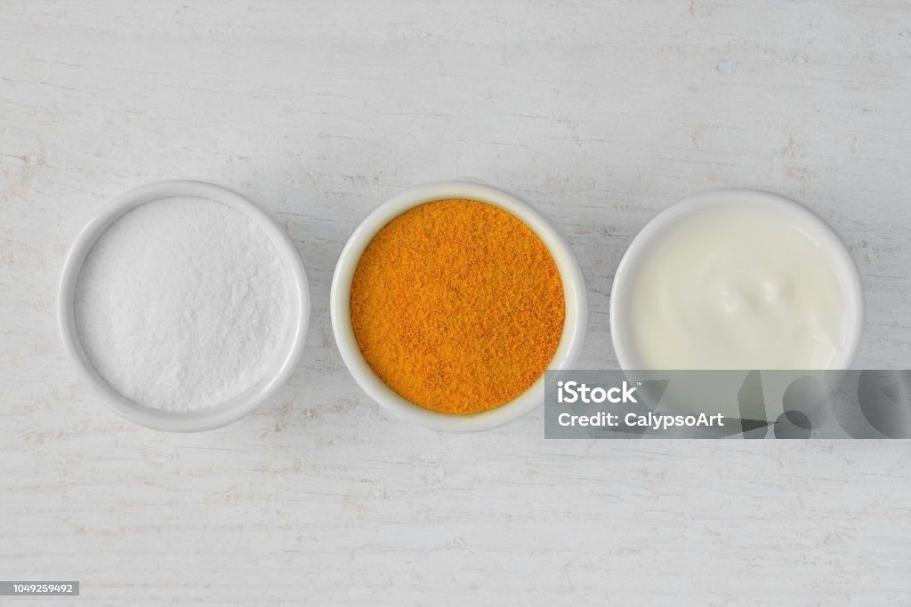 Homemade face mask made out of rice flour, turmeric and yogurt Exfoliation Stock Photo