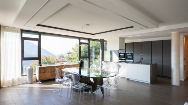 istock Modern kitchen with island and transparent chairs and table 1049265726