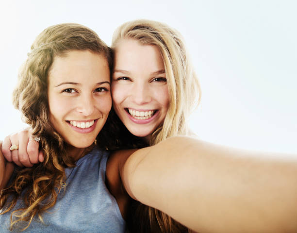 istock Two pretty girlfriends taking smiling selfie 1049266468