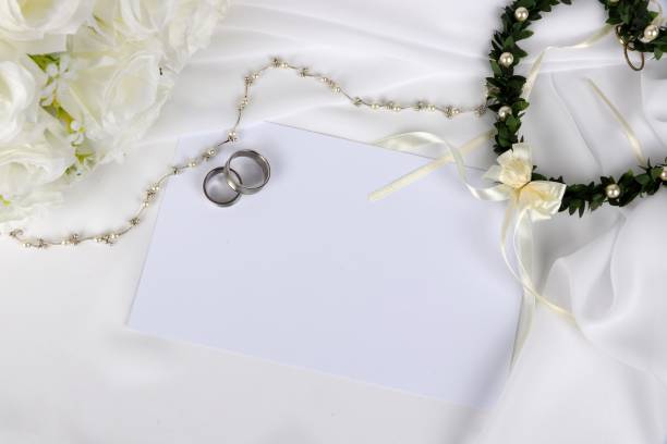 istock wedding invitation - blank wedding invitation with wedding rings and  white roses 1049266830