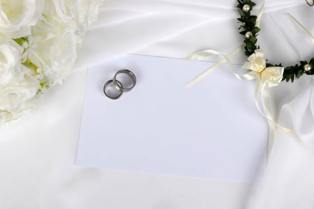 istock wedding invitation - blank wedding invitation with wedding rings and  white roses 1049267514