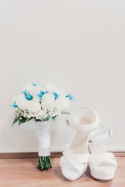 White wedding shoes, white and blue bouquet with roses and chrysanthemums