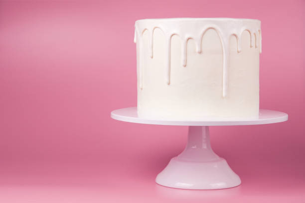 istock White cake with white glaze on a pink background. 1049273784