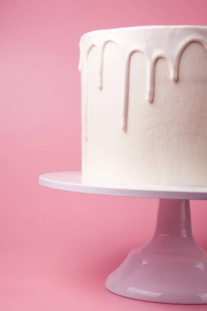 istock White cake with white glaze on a pink background. 1049273786