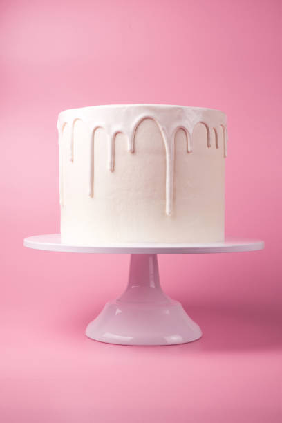 istock White cake with white glaze on a pink background. 1049273788