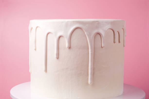 istock White cake with white glaze on a pink background. 1049273820