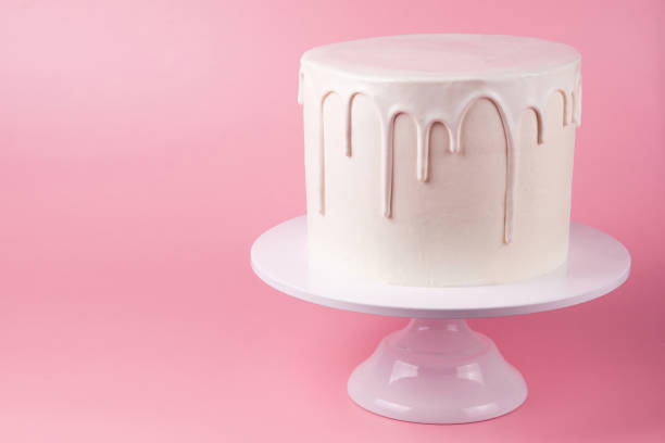 istock White cake with white glaze on a pink background. 1049273822