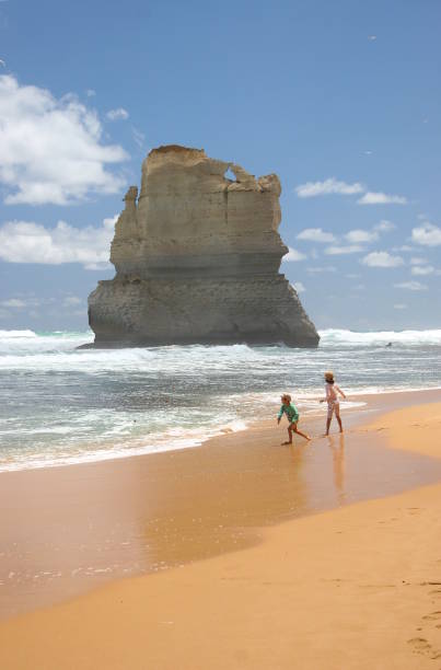 A stunning view of the 12 Apostles along Australia’s Great Ocean Road near Melbourne. The photograph captures the dramatic limestone stacks rising from the Southern Ocean, with waves crashing against the cliffs under a vibrant sky.