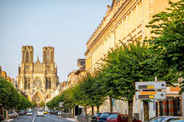 vista a la calle con la catedral en la ciudad de reims, francia - catedral de reims fotografías e imágenes de stock