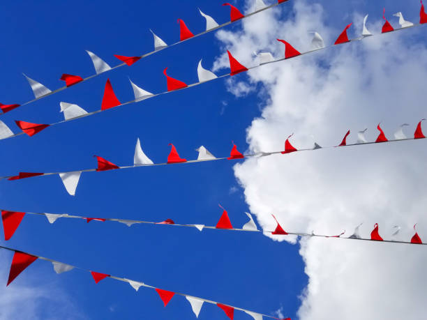 istock Horizontal garland of red and white triangle flags on blue sky 1049281536