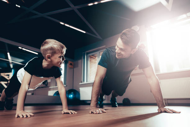 istock Father And Son Are Doing Push Ups In The Gym. 1049282158