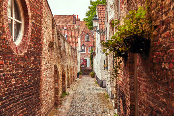 istock Bruges Belgium. Antique brick walls along narrow 1049284988