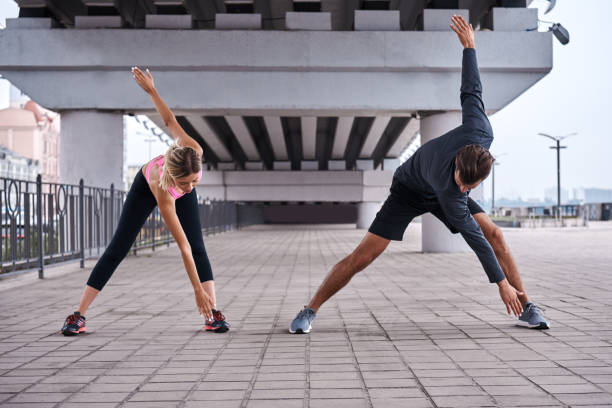 istock Runners team warming up and stretching in city park before morning training 1049285118