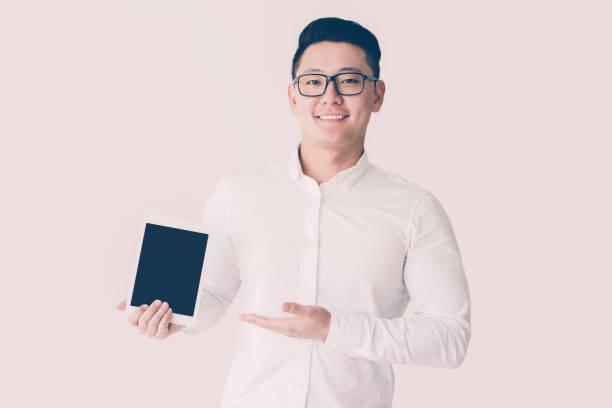 istock Satisfied Korean salesman presenting new device 1049291426