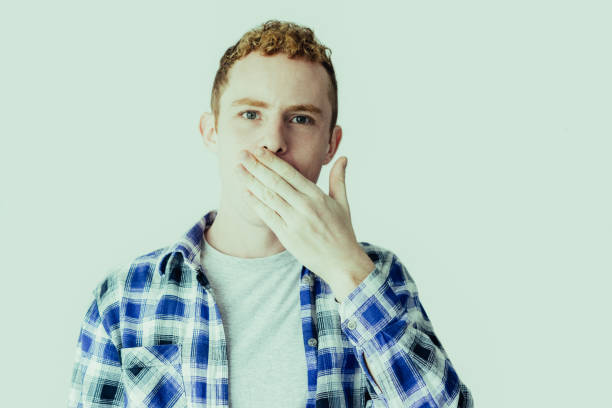 istock Serious Young Caucasian Man Covering Mouth with Hand 1049291504