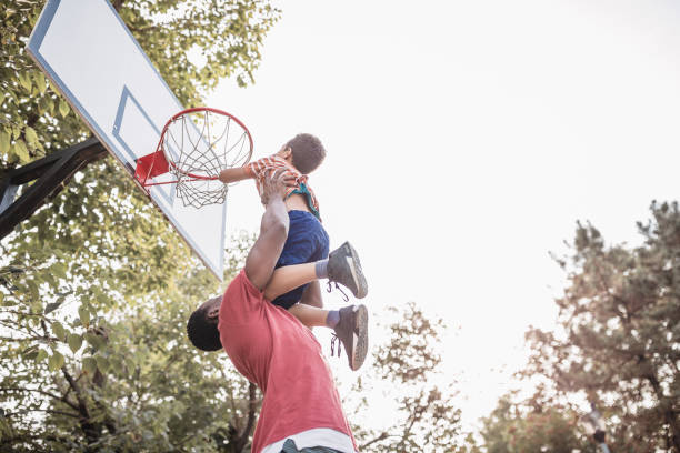 отец и сын веселились, играя в баскетбол на открытом воздухе - action family photograph fathers day стоковые фото и изображения