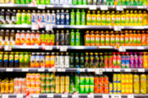 Blurred image of shelf of drink bottles at supermarket