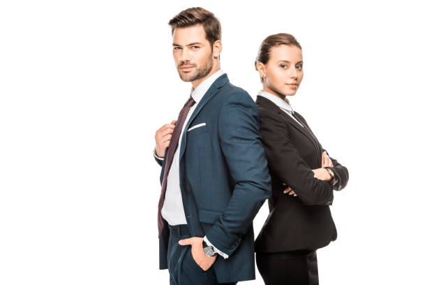istock confident young business partners leaning back to back and looking at camera isolated on white 1049314456