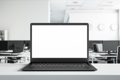 Blank laptop screen with office background