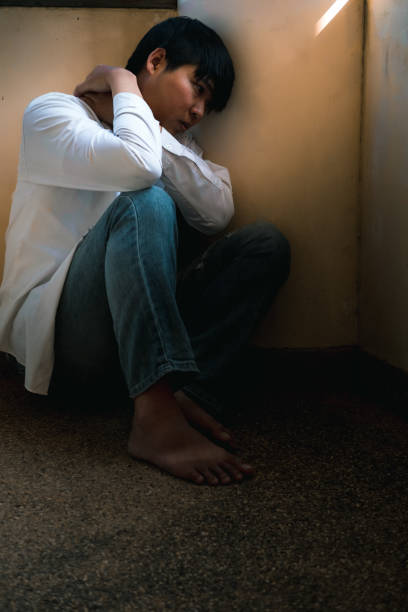 istock Depressed man sitting head in hands on the stairs in building. with low light environment, dramatic concept, concept of Major depressive disorder, unemployed, sadness, depressed and human problems, 1049318018