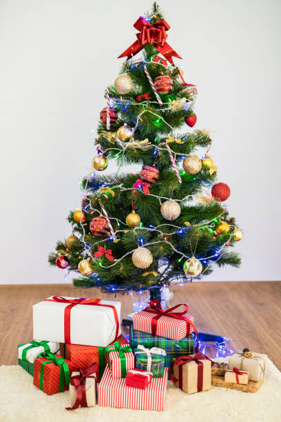 istock The christmas tree with gift boxes on the floor 1049320720