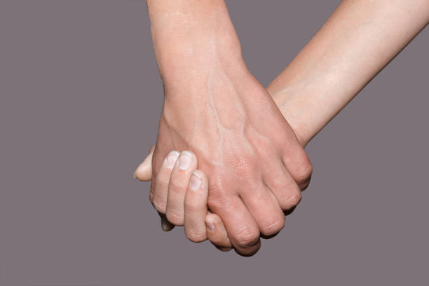 istock female hand holding male hand on background. 1049331894