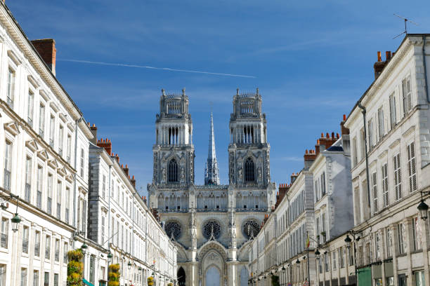 Orleans Cathedral, France Facade of the Cathedral of the Holy Cross (Cathédrale Sainte-Croix d'Orléans). Central perspective image - Joan of Arc Street (Avenue Jeanne d'Arc) with residential buildings left and right hand side. orleans france photos stock pictures, royalty-free photos & images