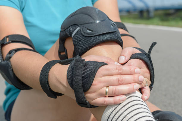 istock Woman rollerskater putting on knee protector pads on her leg 1049338236