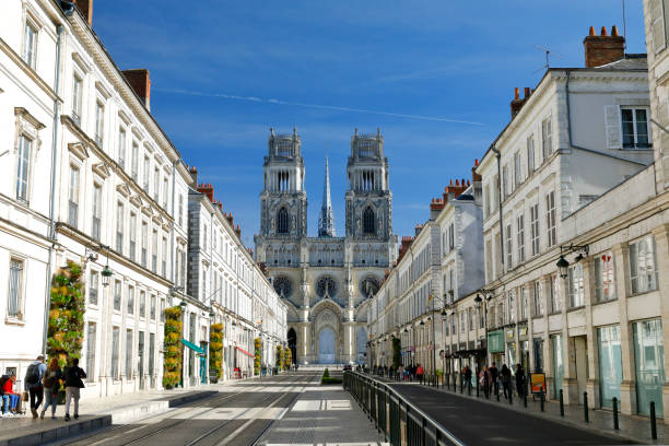 Orleans Cathedral, France Orleans, France - September 29, 2018. Facade of the Cathedral of the Holy Cross (Cathédrale Sainte-Croix d'Orléans). Central perspective image - Joan of Arc Street (Avenue Jeanne d'Arc) with residential buildings left and right hand side. A few people in the streets. orleans france photos stock pictures, royalty-free photos & images