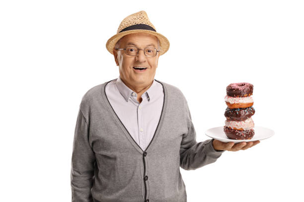 istock Mature man holding a plate of donuts 1049342432