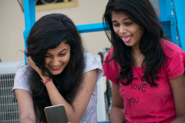 istock two girls taking selfie and making funny face expressions 1049346732