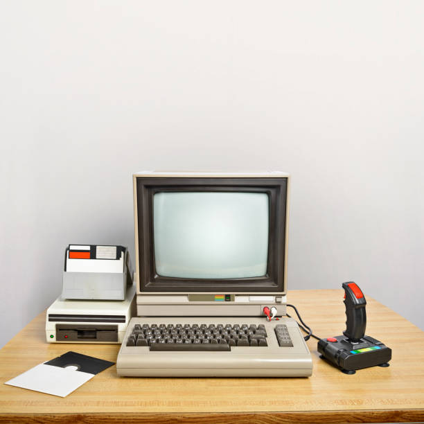 Old computer on a desk An old computer on a desk with a joystick and floppy disks. 
Blank screen to insert your own message. 
Large copyspace in the background. game controller photos stock pictures, royalty-free photos & images