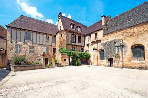 Ancient courtyard leading to this imposing set of buildings of timber frame construction, typical of the homes and houses found in the backstreet alleyways between buildings of stone construction in the ancient medieval old town of Sarlat, in the department of Dordogne, southwest France