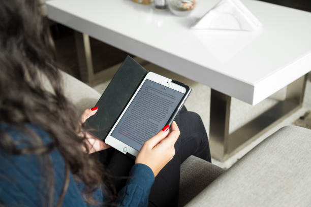 Young woman peacefully reading eBook on tablet stock photo