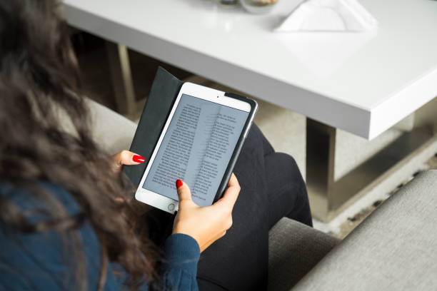 Young woman reading eBook on tablet stock photo