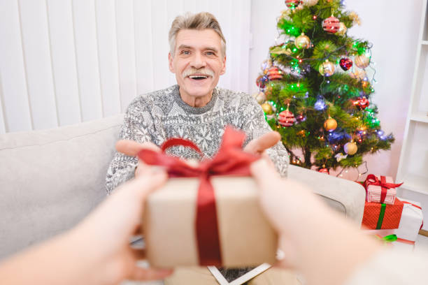 istock The hands with a gift box for a happy old man 1049354910