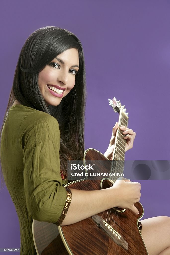 Belle brunette jouer de la guitare acoustique - Photo de A la mode libre de droits