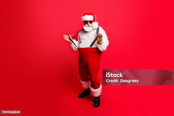 Full Length Body Size Di Allegro Positivo Ottimista Felice Babbo Natale Tirando Pantaloni Bretelle Pronte A Festa Festa Congratulazioni Congratulazioni Auguri Vendita Sconto Isolato Su Sfondo Rosso - Fotografie stock e altre immagini di Babbo Natale